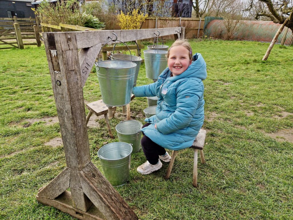 Learning to milk a cow at Gressenhall Farm