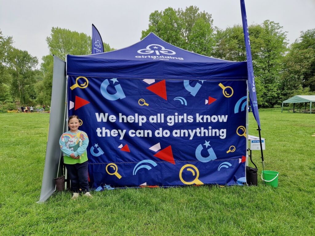 7 year old girl stood in front of a Girlguiding tent