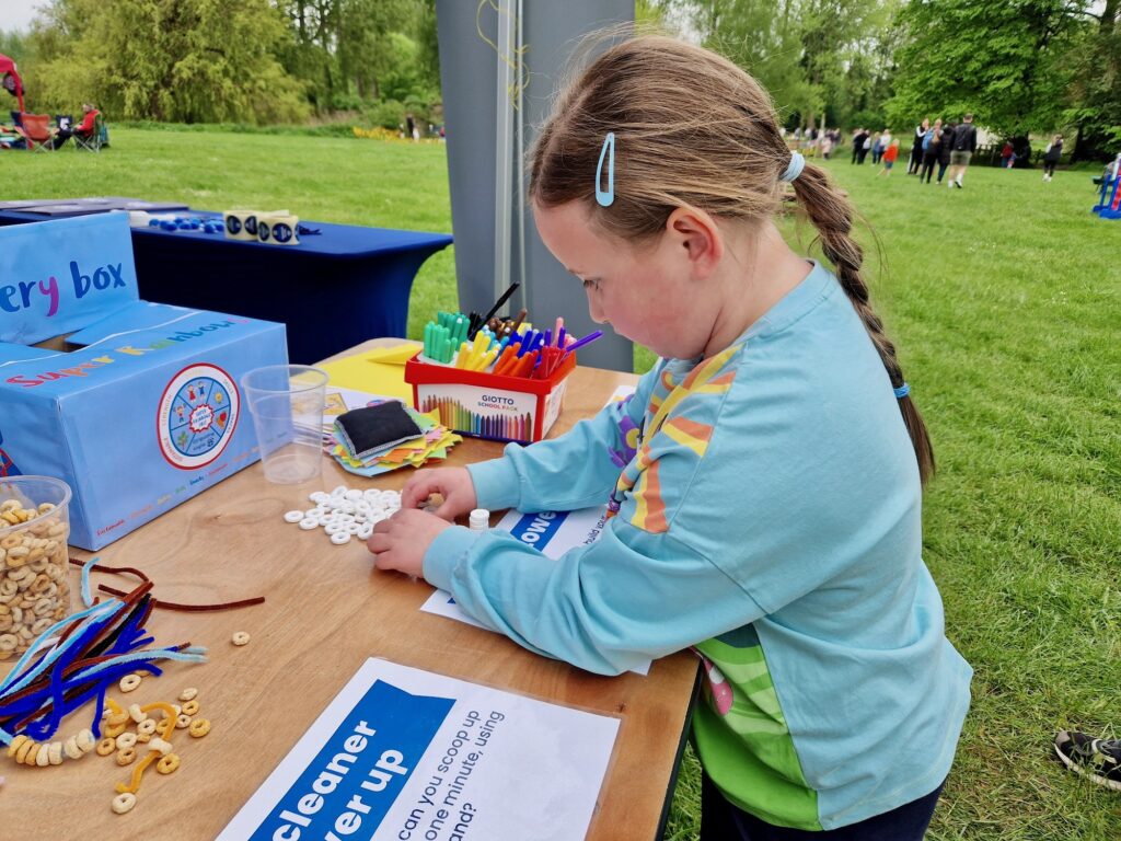 7 year old girl trying games at a Girlguiding tent