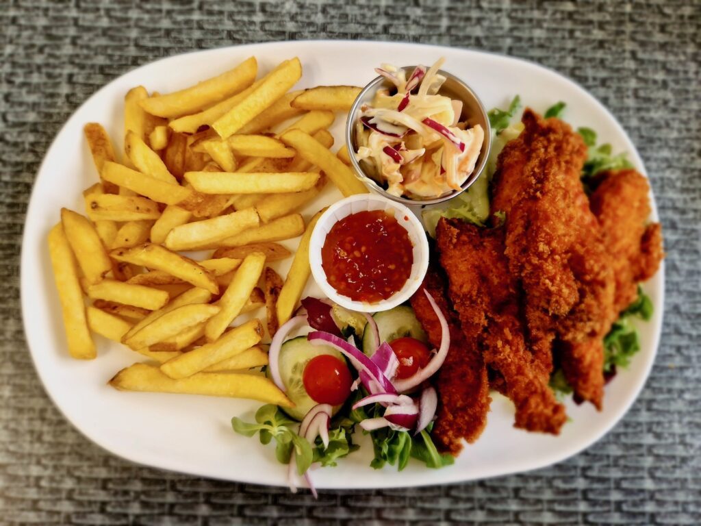 Chicken goujons meal, consisting of chicken goujons, chips, salad, coleslaw and sweet chilli dipping sauce