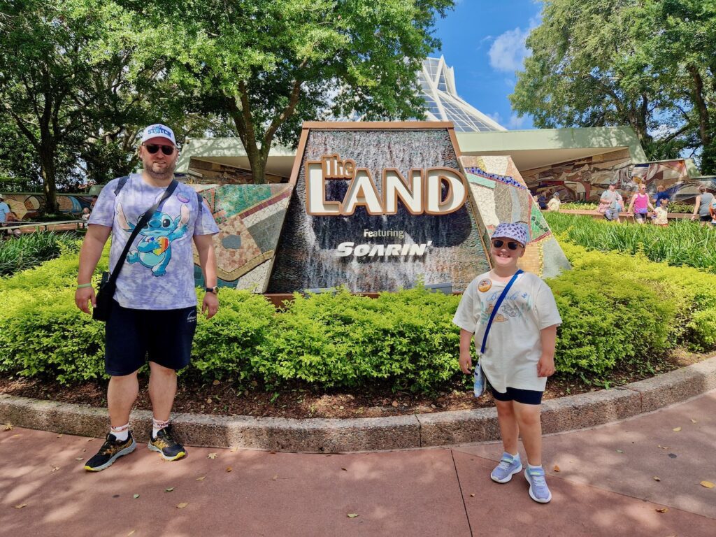 Erin and John stood next to The Land and Soarin' sign at Epcot