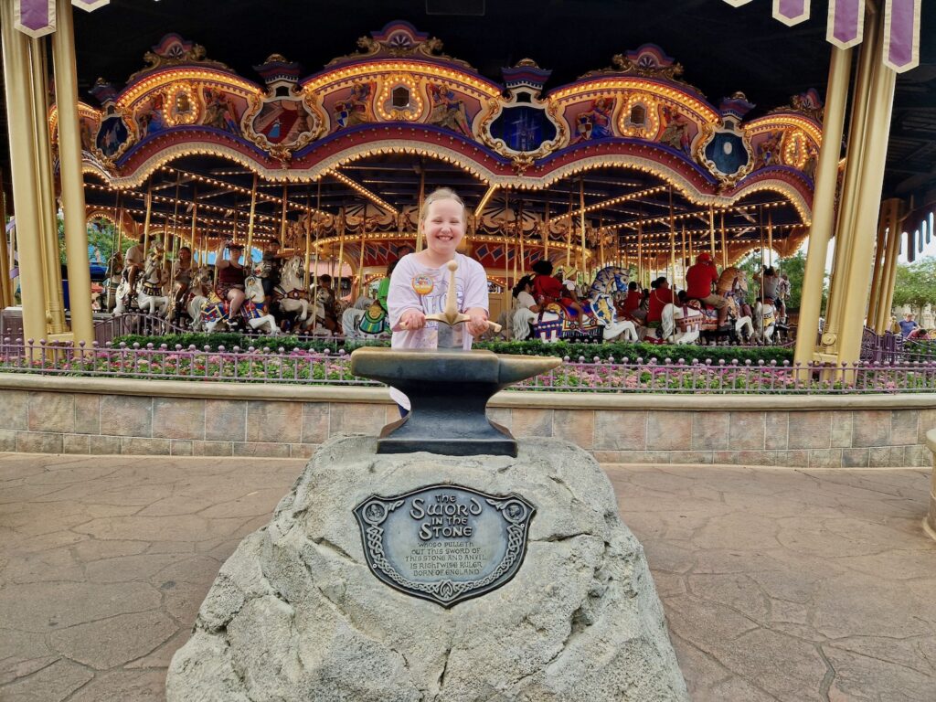 Erin trying the Sword in the Stone at Magic Kingdom