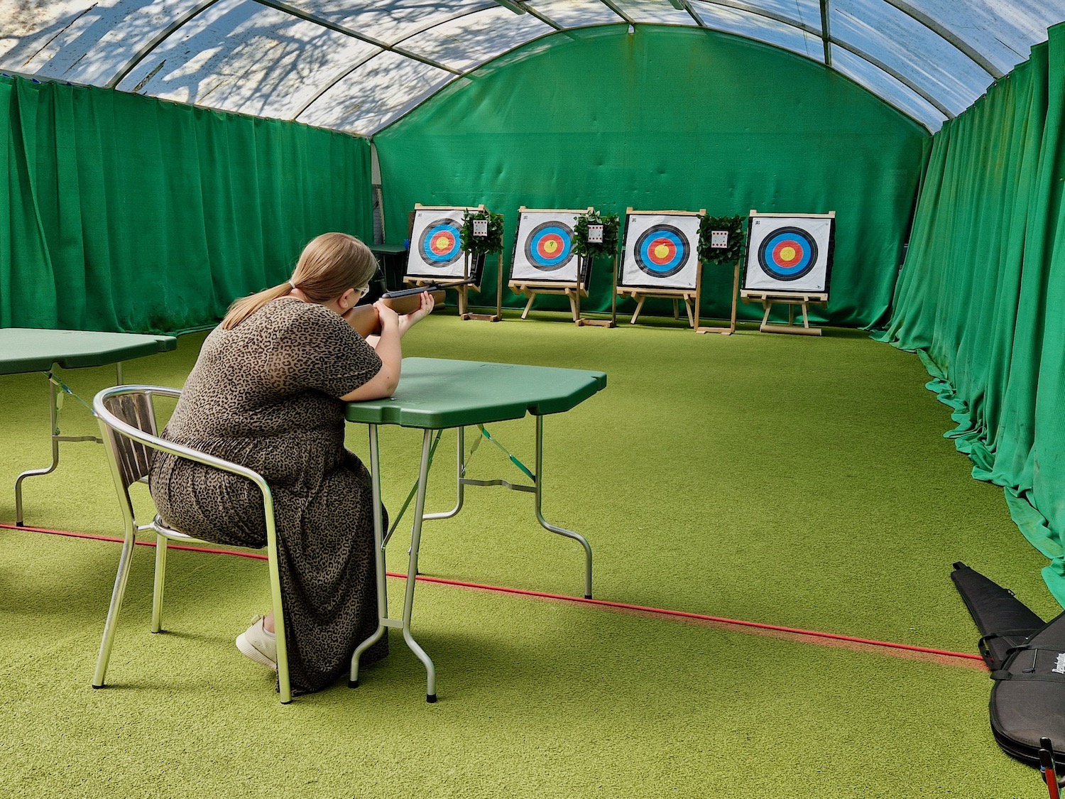 38 year old woman, wearing a brown animal print dress, taking part in a target shooting session at Haven Wild Duck