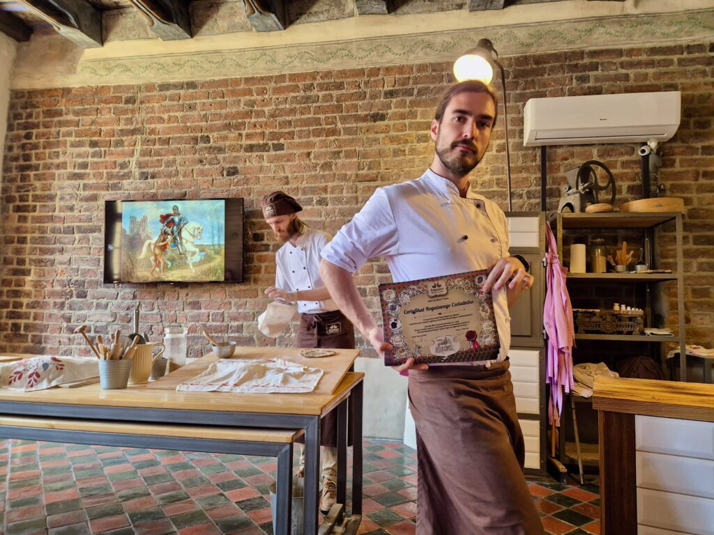 Staff holding a certificat at the Poznan croissant museum