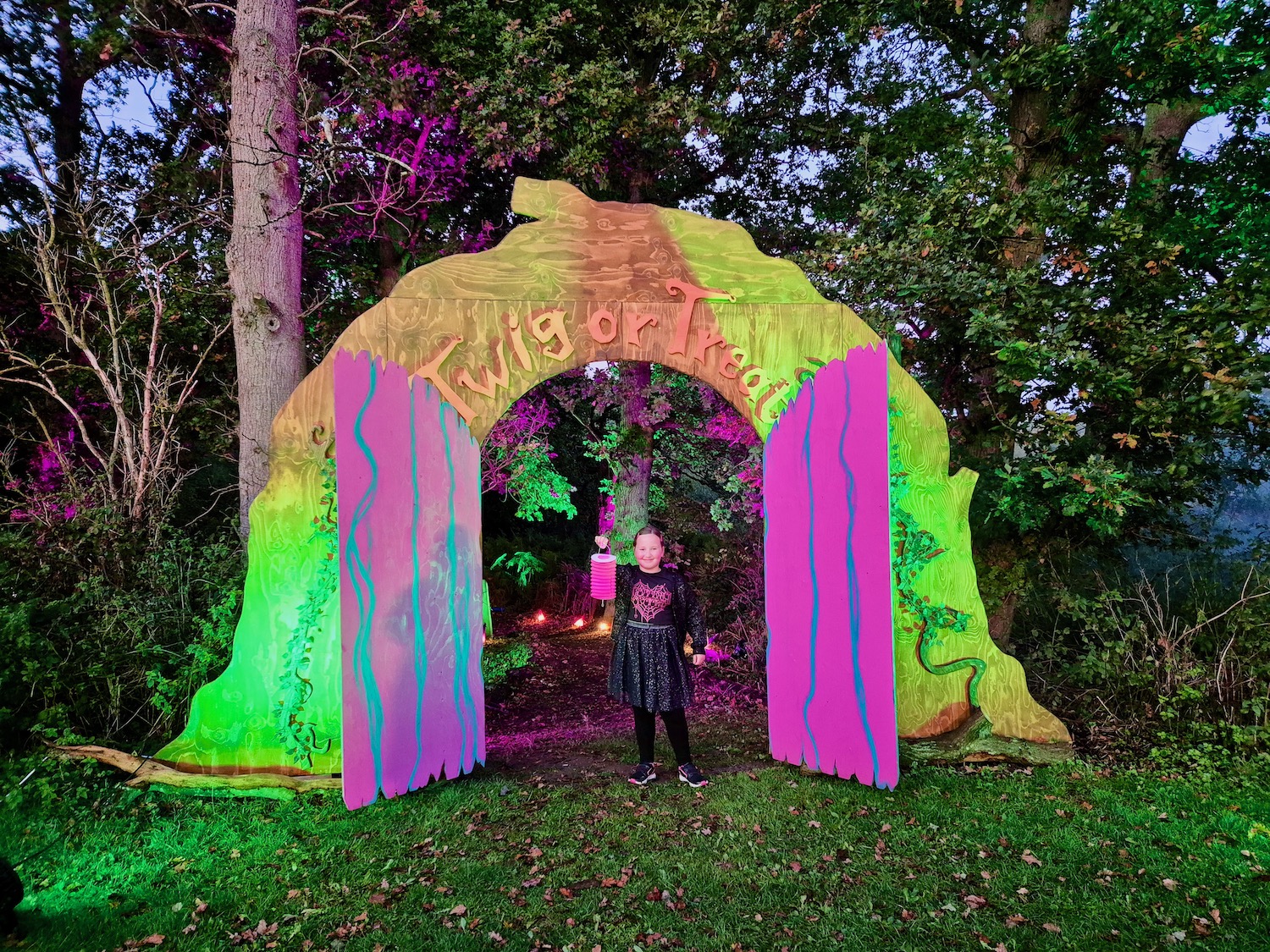 Erin stood in a lit up doorway at Twig or Treat at Bewilderwood Norfolk