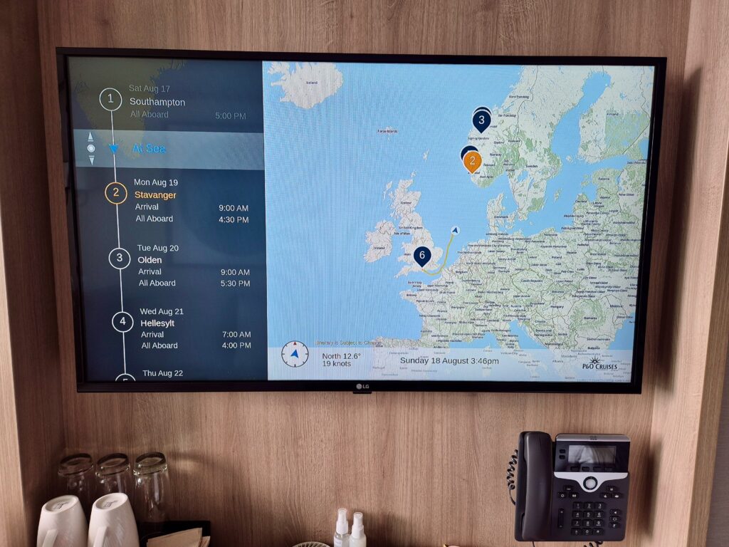 A cruise cabin TV screen displaying the P&O Iona itinerary and a map of the ship’s current location near Norway.