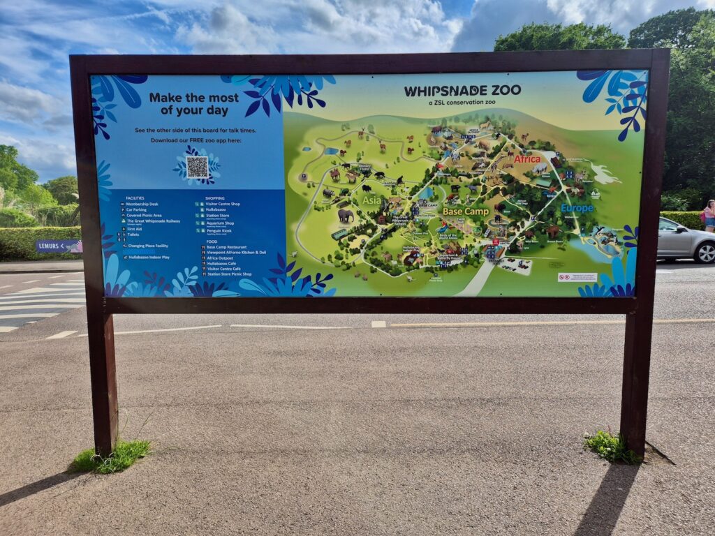 Illustrated map of Whipsnade Zoo displayed on a large outdoor board, showing key animal zones and visitor facilities.