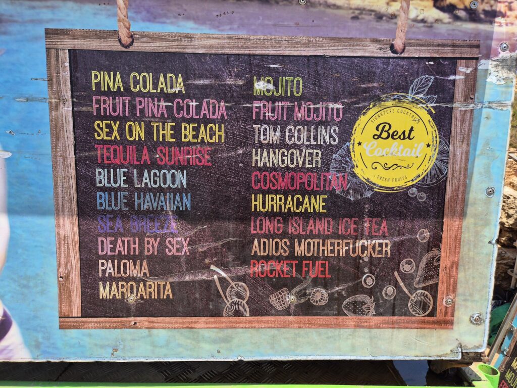 Cocktail menu sign with a variety of drinks available at a beach bar near the Blue Lagoon in Comino, Malta