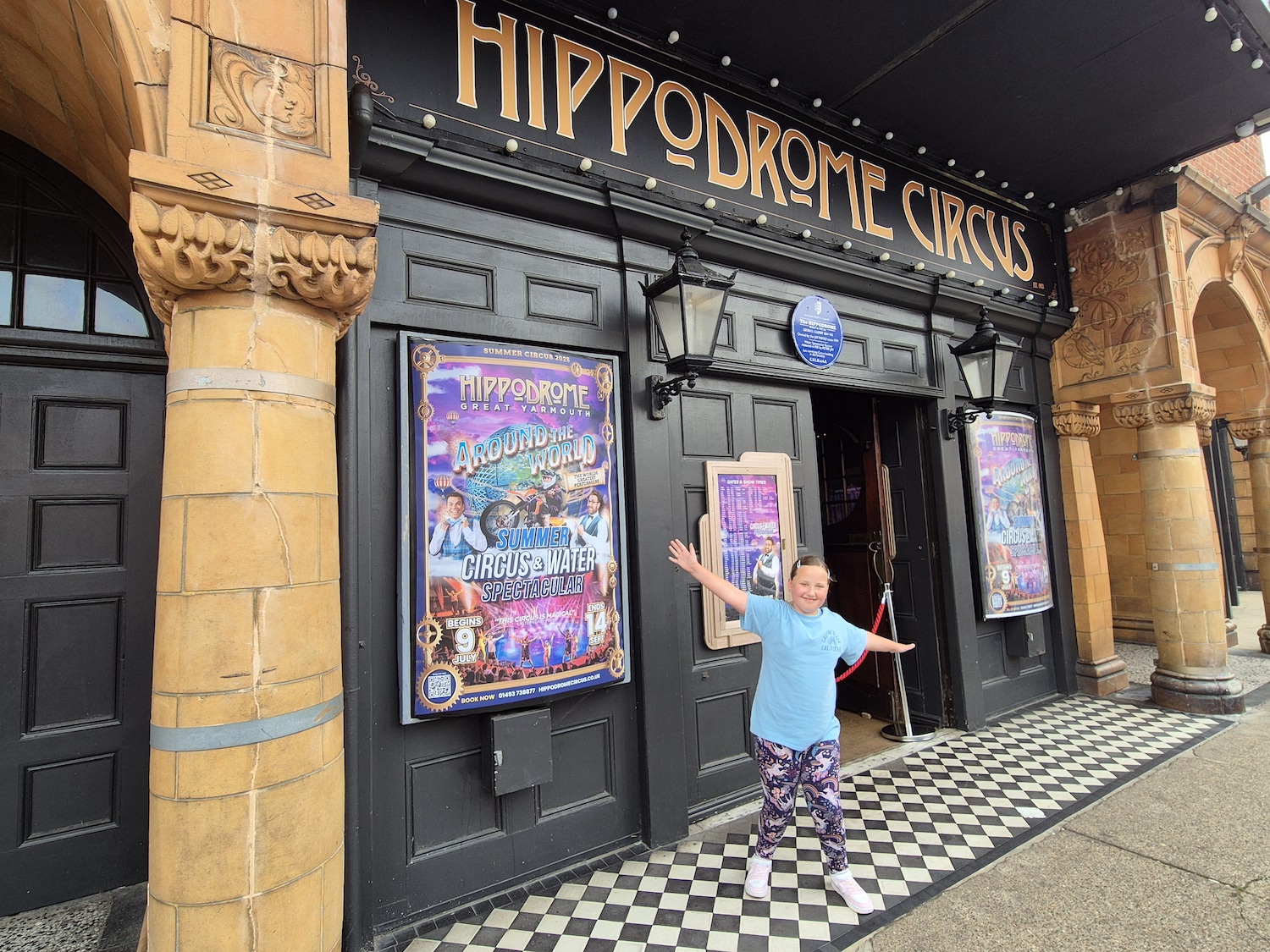 Young girl in bright clothes stood outside the Hippodrome Circus in Great Yarmouth