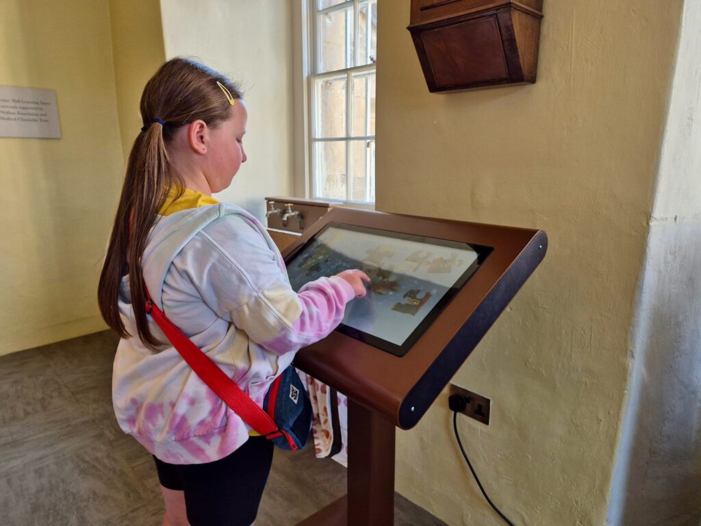 Child using an interactive touchscreen activity at No. 1 Royal Crescent in Bath