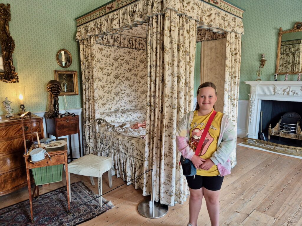 Child standing in a Georgian bedroom with a four-poster bed at No. 1 Royal Crescent in Bath